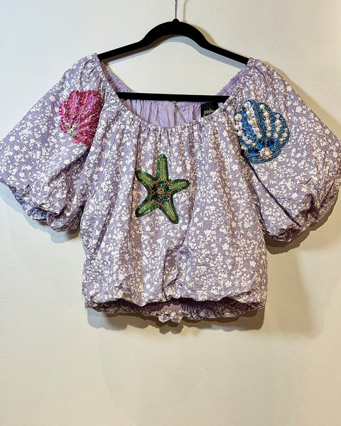 Top de hombro caído con detalles bordados
