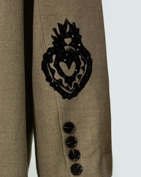 Gabardina detalle de mano con corazón en llamas