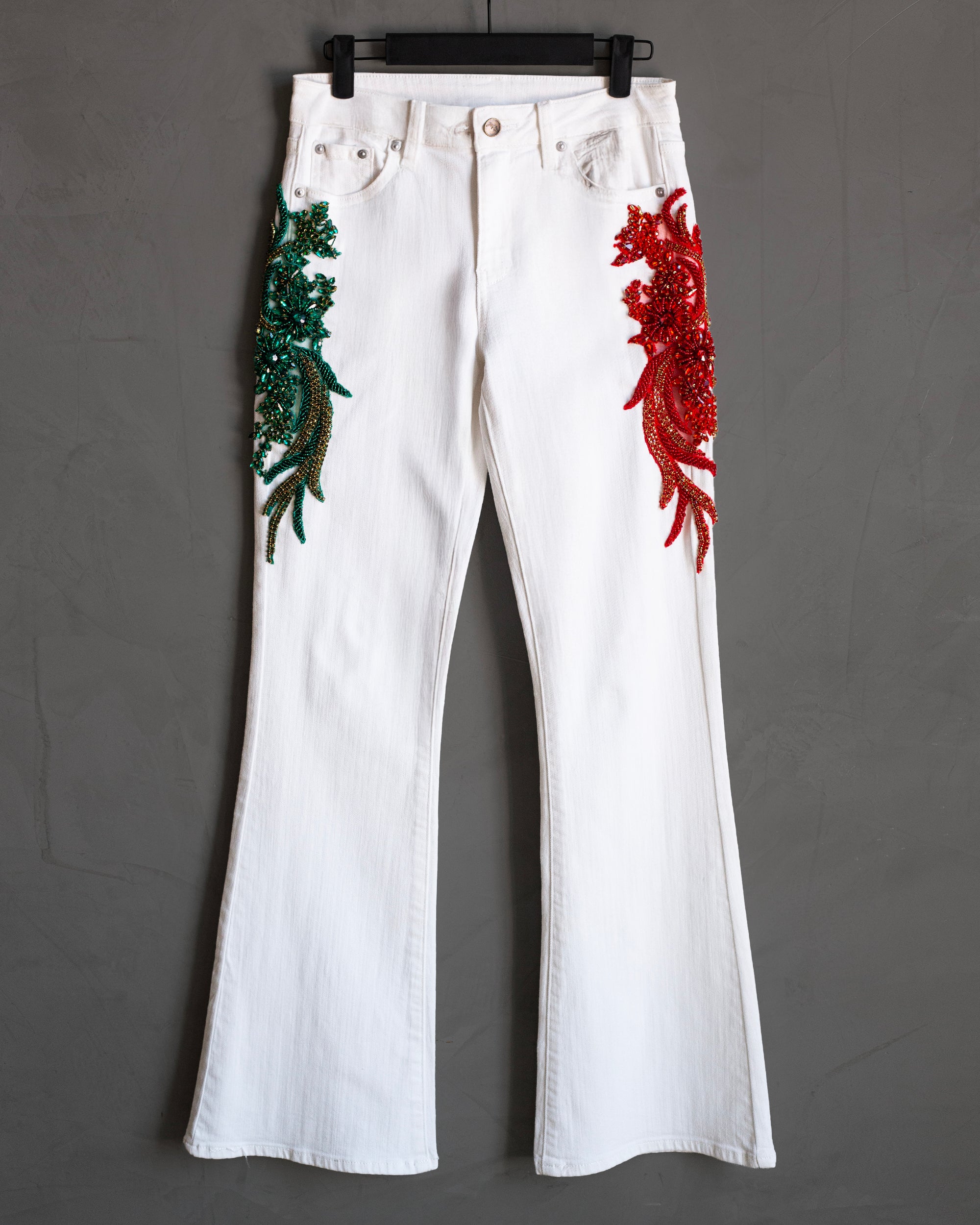 Flared jeans blancos con aplicaciones verde y rojo
