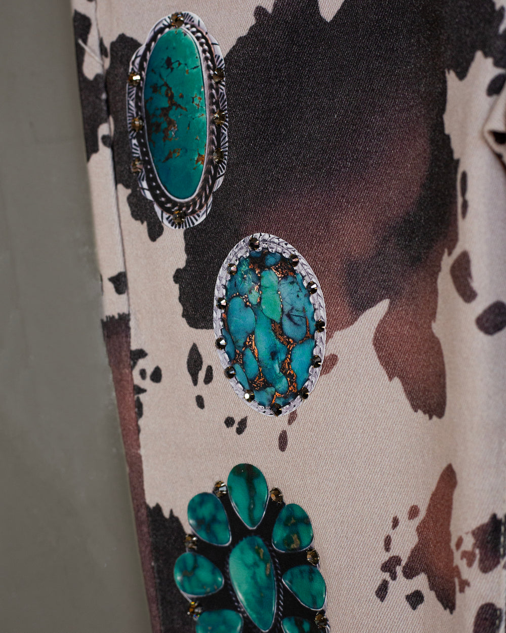 Flared jeans cowprint con turquesas