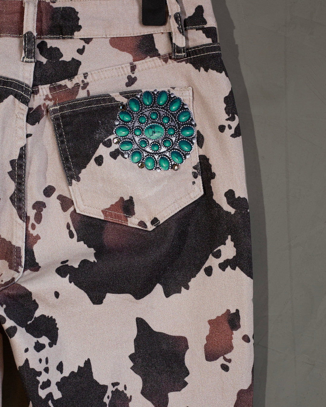Flared jeans cowprint con turquesas