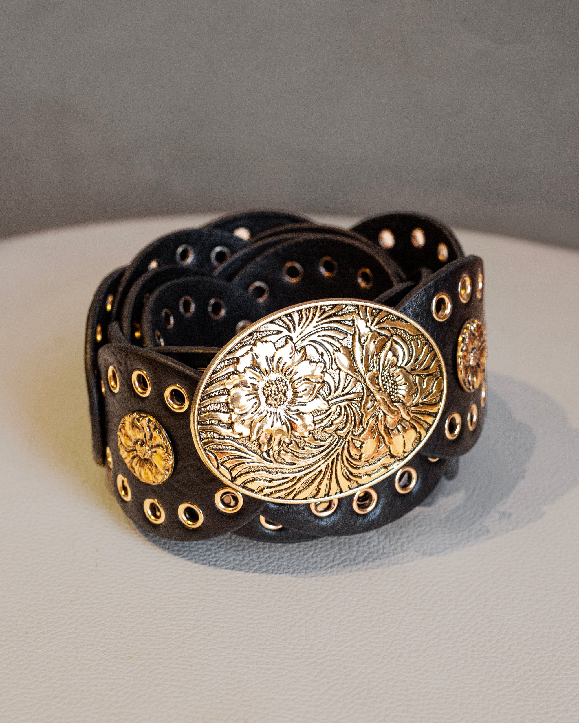 Cinto negro ancho de polipiel con estoperoles dorados